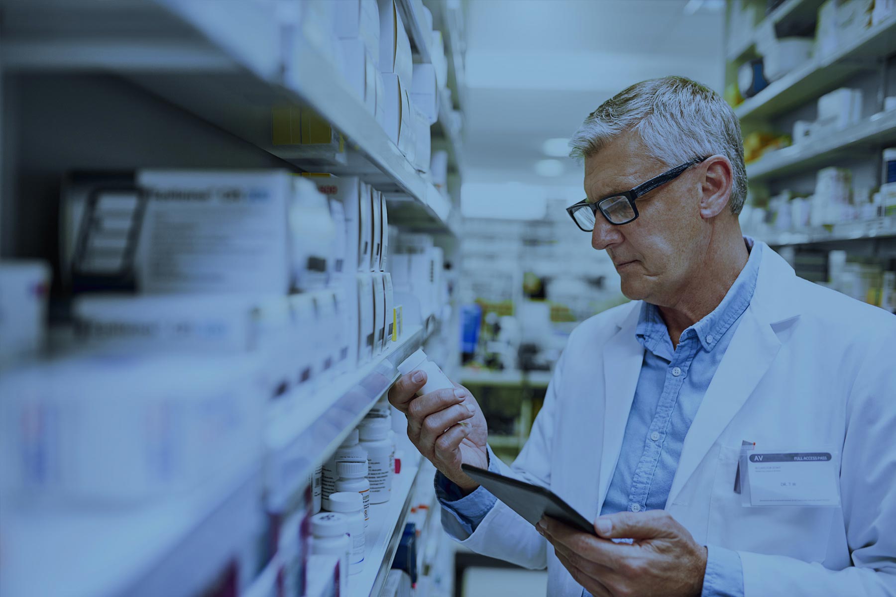 Pharmacist reading bottle of generic drugs